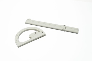 A tactile smart ruler and smart protractor designed for visually impaired users. The ruler has raised markings and an adjustable slider, while the protractor features tactile notches and a rotating arm. Both have small markers for use with an assistive reading system.