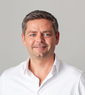 A photo of Matapo's CEO, Jan Šimík. He has short brown hair, light blue eyes, and a slight smile, and is wearing a white collared shirt against a neutral background.