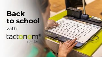 A person is interacting with a tactile reading device called tactonom reader. The image shows the person's hand tracing a maze on a tactile graphic displayed on the device. The background features a soft focus, highlighting the person’s engagement with the device. The text "Back to school with tactonom reader is prominently displayed on the left side of the image, blending seamlessly with the overall design. The scene suggests an educational setting, emphasizing the use of the device for accessible learning.